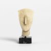 Minimalist stone sculpture of stylized human head