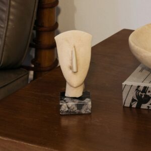 Abstract stone face sculpture on marble base