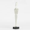 Abstract white human figure sculpture on black base