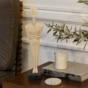 Wooden abstract figurine on side table with candle