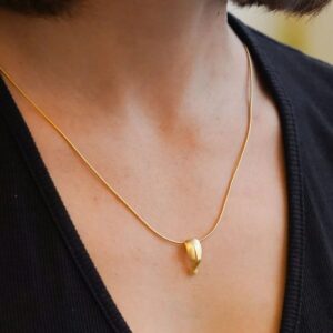 Gold pendant necklace on person's neck