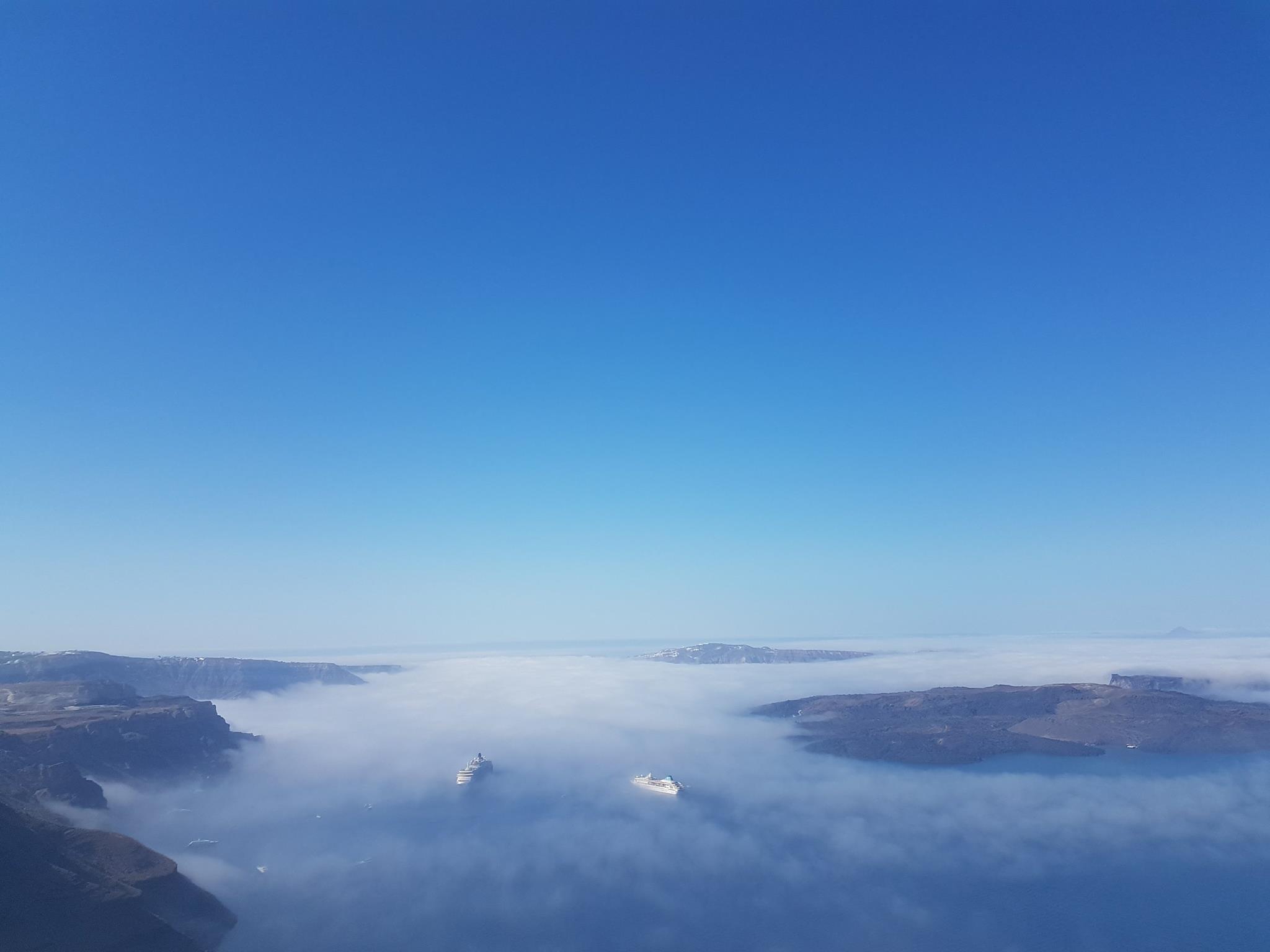 Cruise ships in foggy coastal caldera