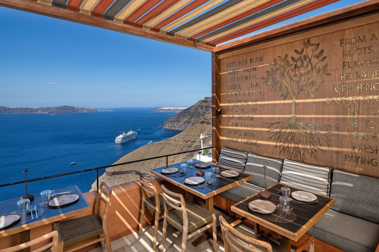 Cliffside restaurant terrace overlooking Santorini caldera