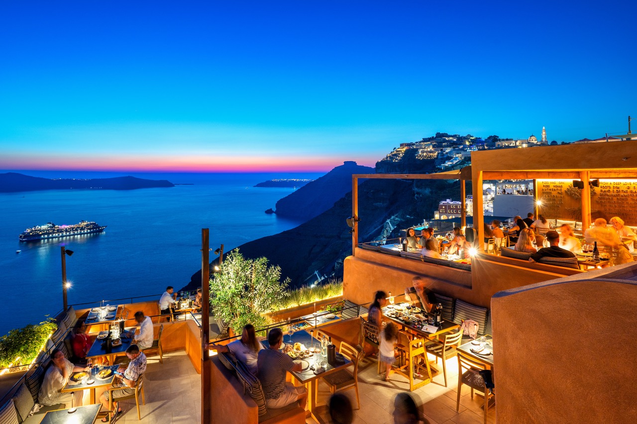 Cliffside restaurant overlooking sea at sunset