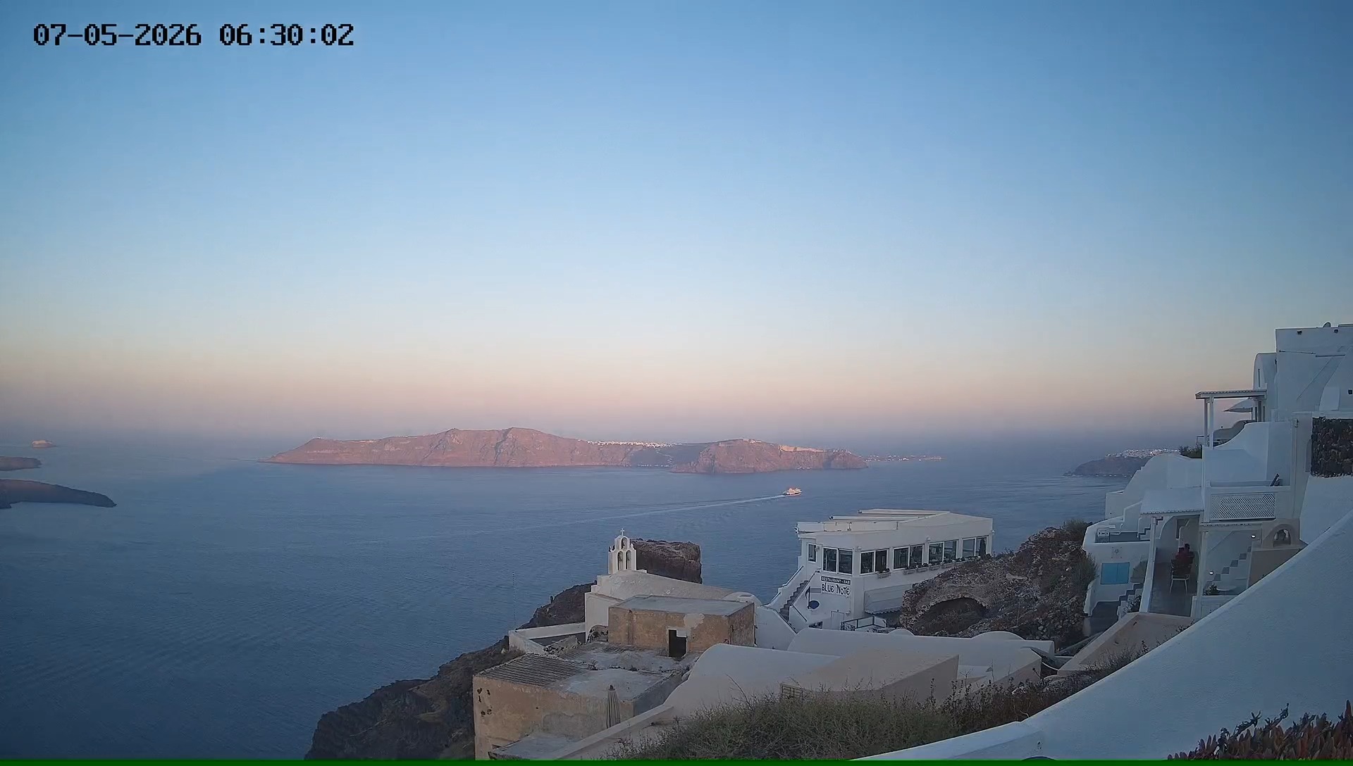 Sunrise over Santorini cliffs and Aegean Sea