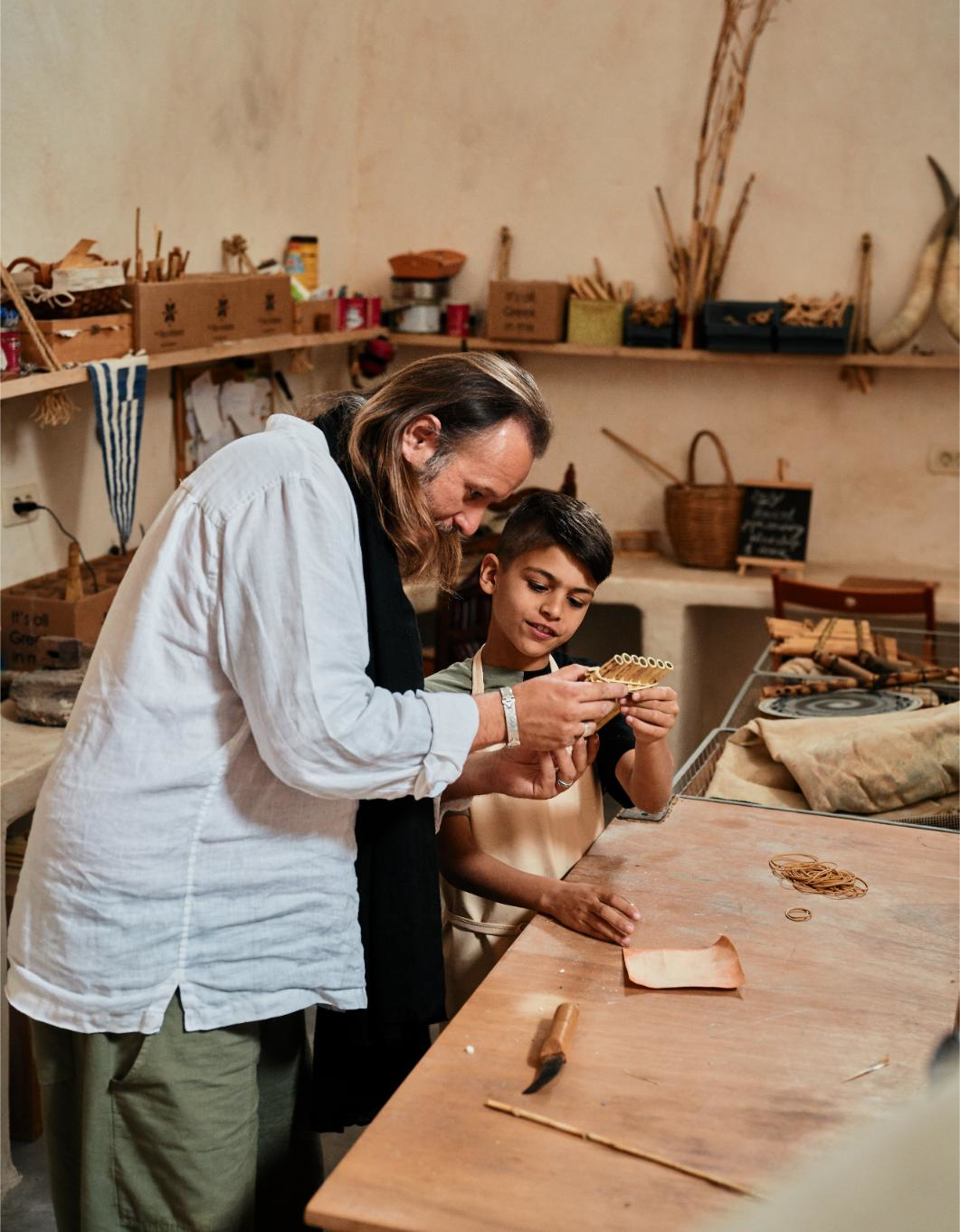 Adult and child crafting leather in workshop