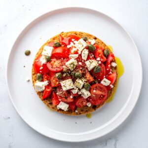 Cretan Dakos with tomato feta and caper, drizzled with olive oil