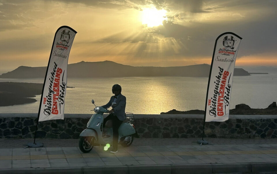 Person on scooter at Santorini sunset viewpoint