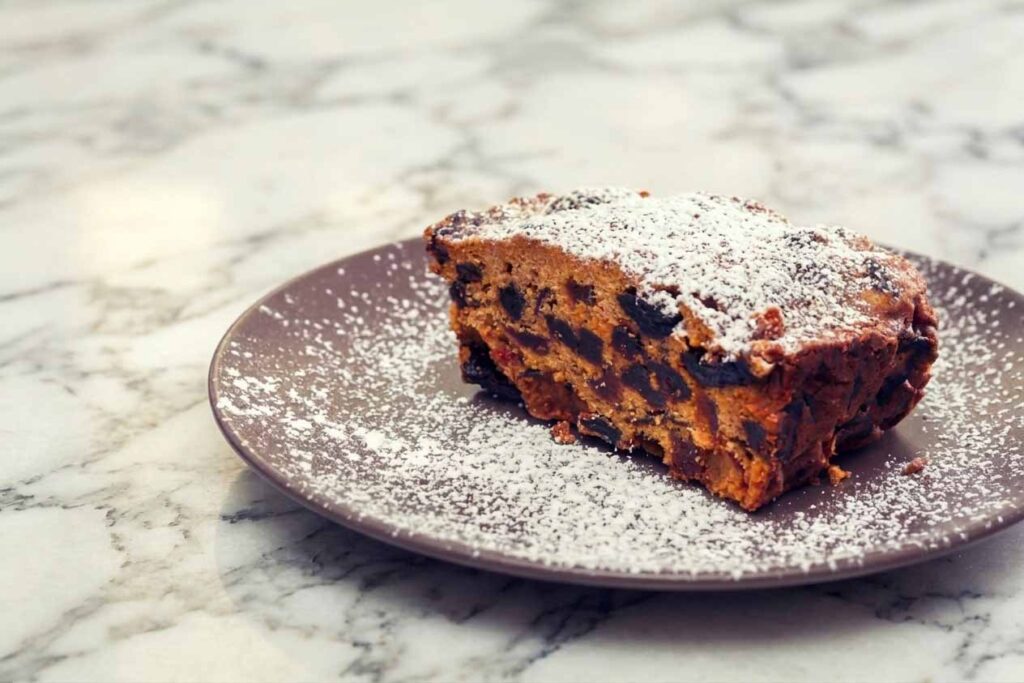 Powdered sugar-dusted chocolate chip blondie on a gray plate