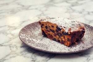 Powdered sugar-dusted chocolate chip blondie on a gray plate