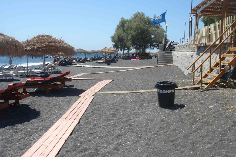 Black sand beach with loungers and umbrellas