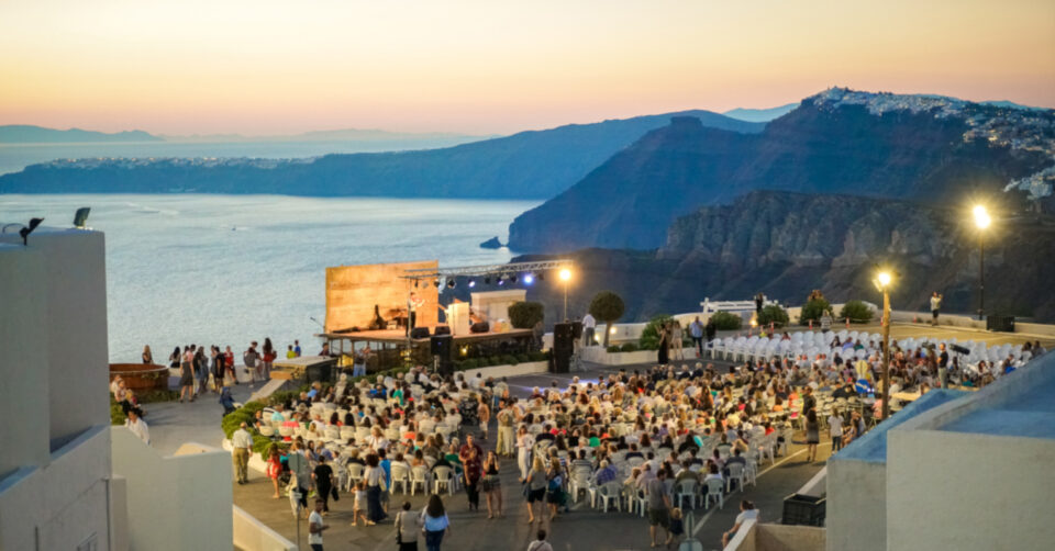 Outdoor seaside concert at sunset overlooking cliffs