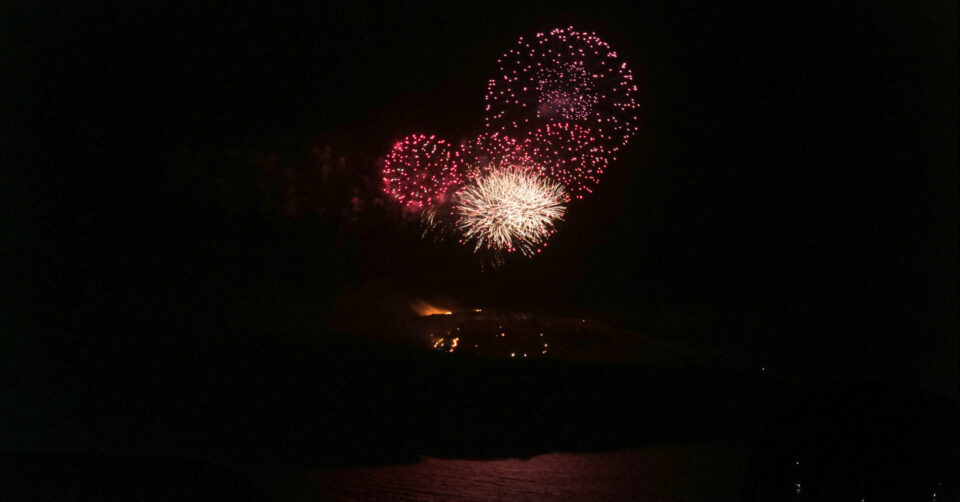 Colorful fireworks bursting over water at night