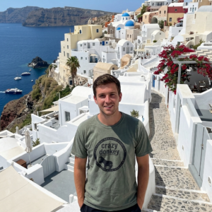 Man in Santorini overlooking white cliffside village