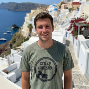 Man in Santorini with white cliffside buildings