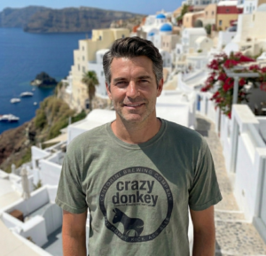 Man in Santorini with white cliffside buildings