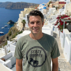 Man in Santorini with white cliffside buildings