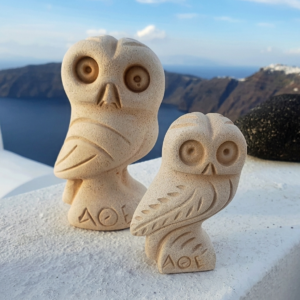 Two stone owl figurines overlooking seaside cliffs