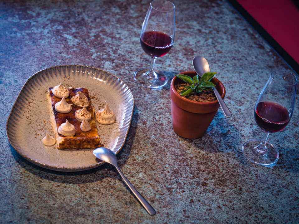 Gourmet dessert with red wine glasses on table