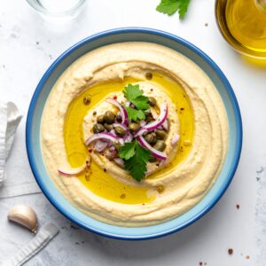 Creamy Santorinian Fava topped with capers, red onion, parsley, and olive oil