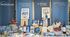 Santorini-themed shop display with souvenirs, artwork, wine, and model boats
