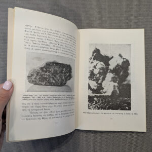Hand holding open Greek book with black-and-white photographs