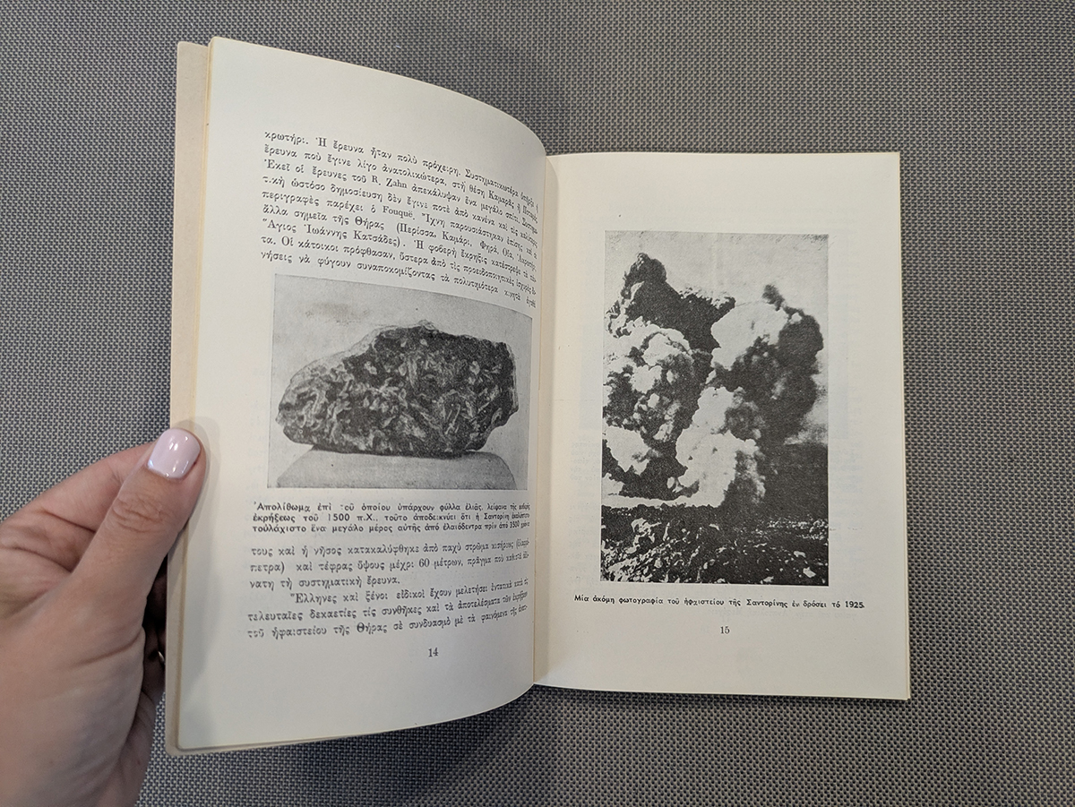 Hand holding open Greek book with black-and-white photographs